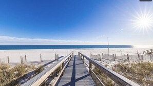 A wooden boardwalk leading to a beach with clear skies and calm sea. - Perdido Sun #802 - Little Piece of Paradise on the Beach! Large Balcony! (Pensacola)
