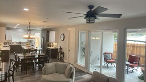 Un'ampia zona giorno con ventilatore a soffitto, un tavolo da pranzo con sedie e un divano.