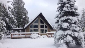 A lodge with a triangular roof, large windows, and a wooden deck. - Cottonwood Chalet (Packwood)