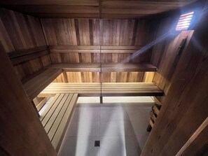 En sauna med træbænke og flisegulv.