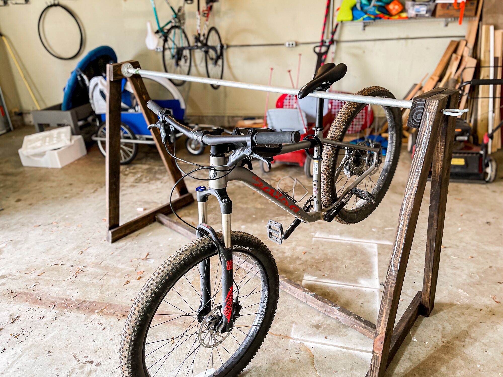 Una bicicleta en un taller con herramientas y equipo al fondo.