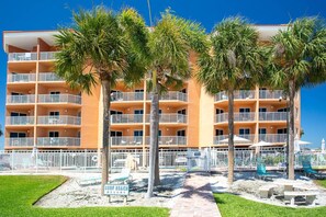 A multi-story hotel with balconies, palm trees, and a sign reading 'Surf Beach Resort.' - Beachfront Condo. Heated Pool. Activities, Fun, End Unit, Parking, & Great Location! (Treasure Island)