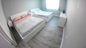 Un dormitorio con dos camas, un escritorio y una ventana.