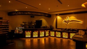 A dimly lit bar area with a curved counter and decorative lighting.