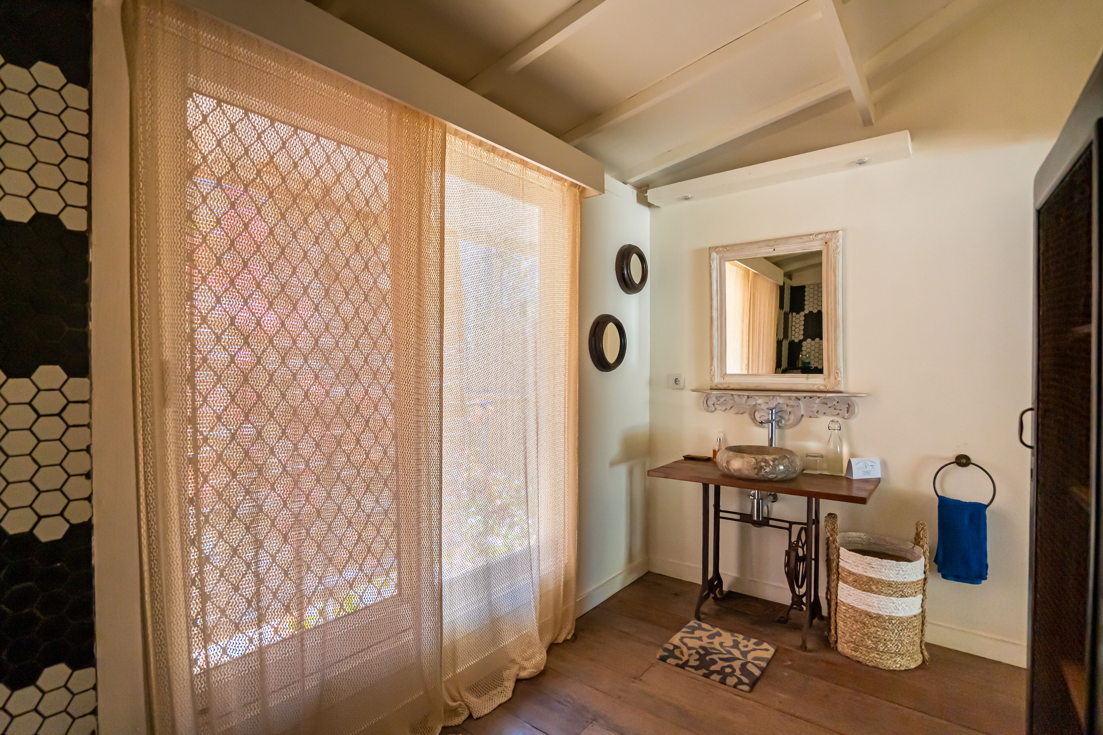 A bathroom with a sink, mirror, and a woven basket.