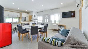A modern apartment with a dining area, kitchen, and living room. - Seafront Holiday Apartment Inga with sea view (Vir)