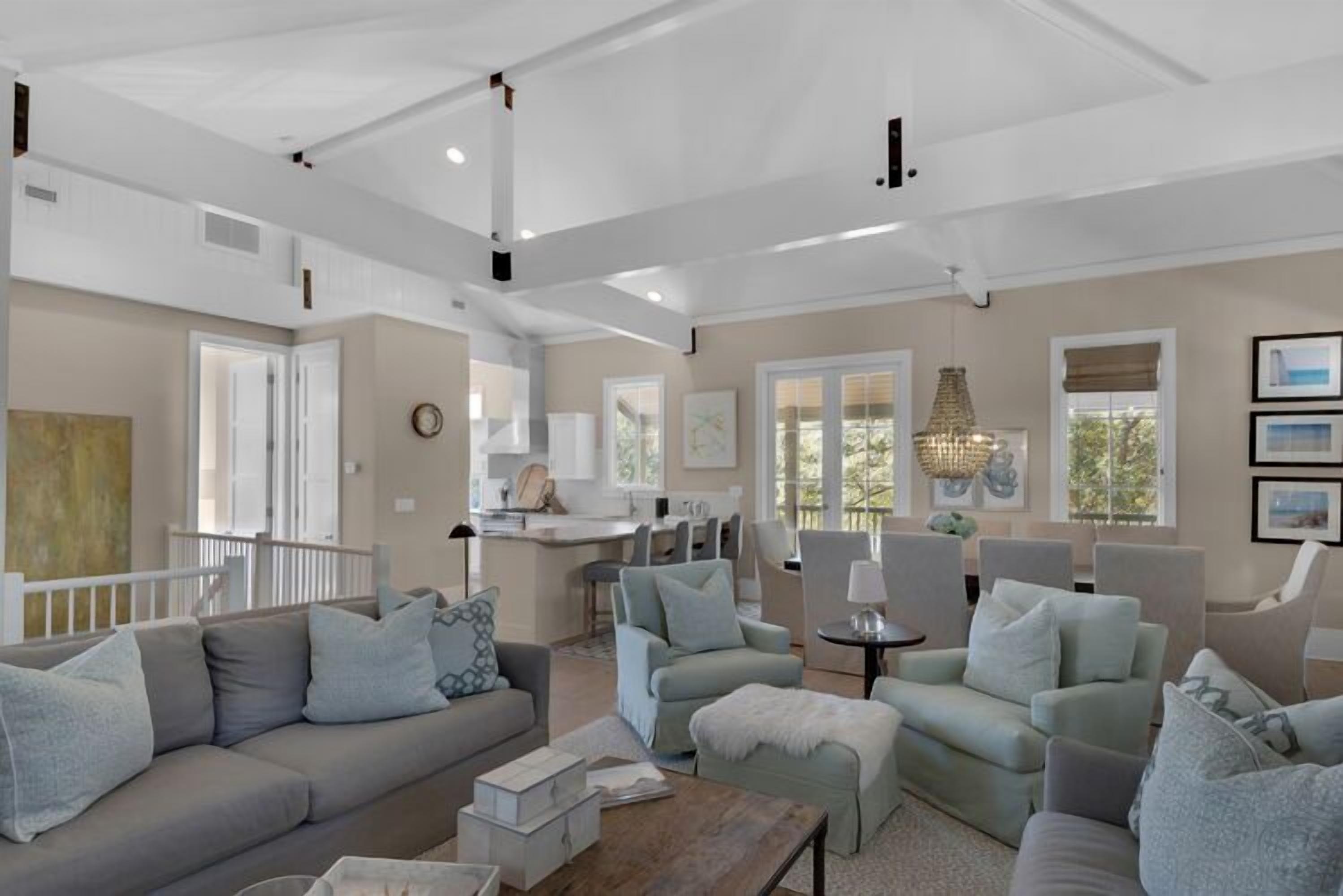 A spacious living room with a neutral color palette, a dining area, and a kitchen.