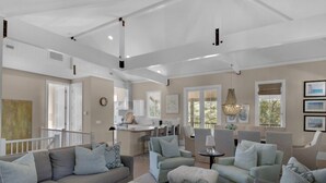 A spacious living room with a neutral color palette, a dining area, and a kitchen.
