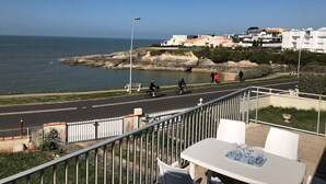 Une vue sur la côte, avec une route, un banc et une table entourée de chaises.