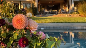 A pool area with a house in the background.