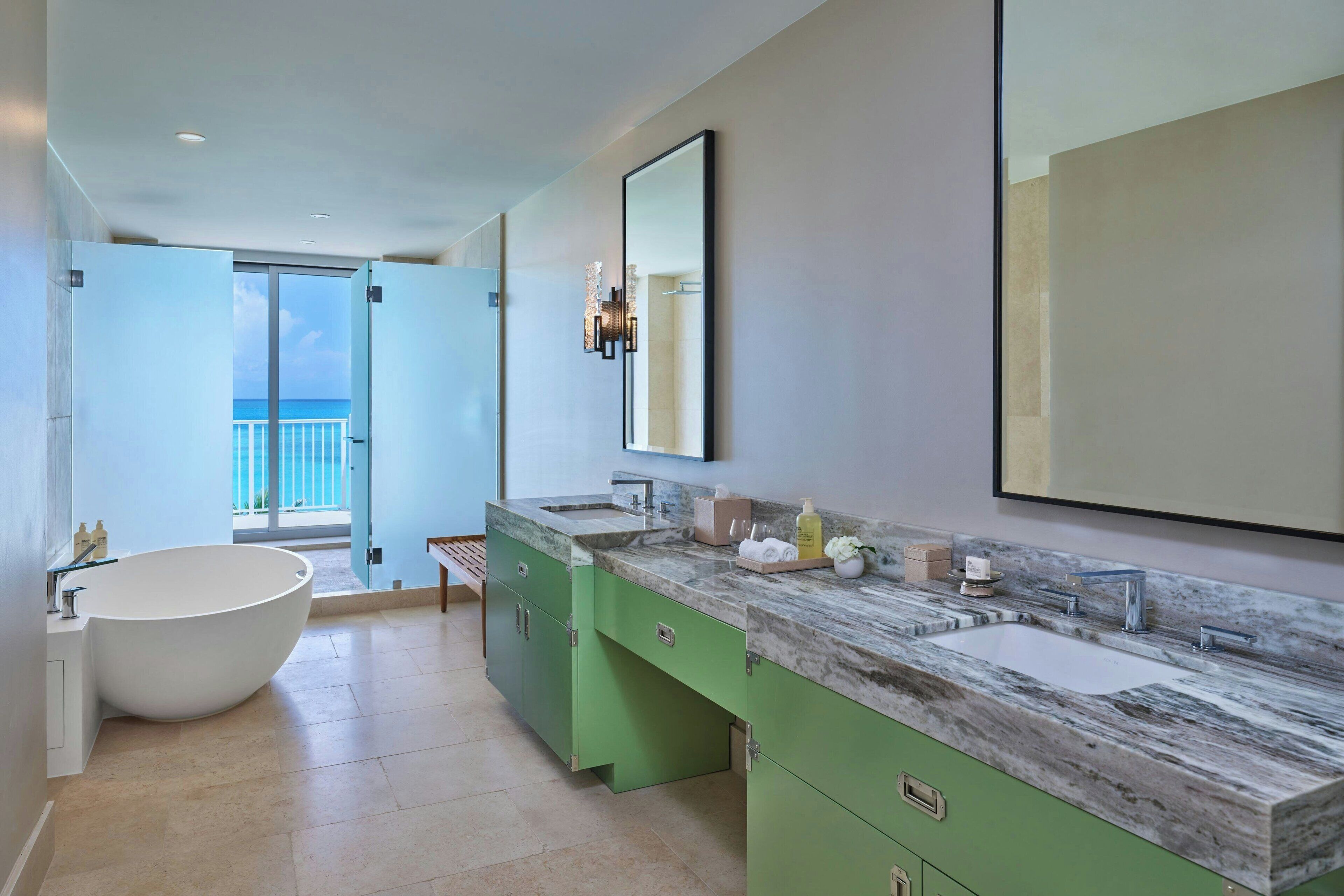 A modern bathroom with a freestanding bathtub, dual sinks, and a large mirror.