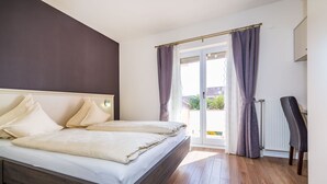 Un dormitorio con cama, radiador y vistas al exterior.