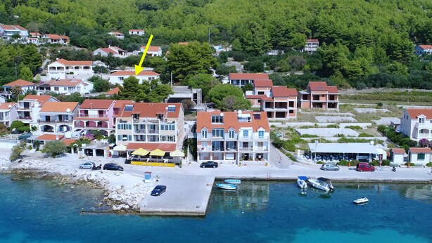 A coastal town with buildings along the waterfront, a pier, and boats. - Apartments K & N (Blato)