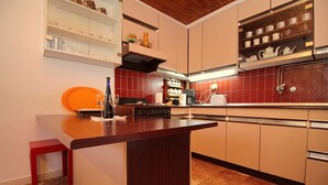 A kitchen with a central island, built-in shelves, and a tiled backsplash. - Apartment Kim (Lumbarda)