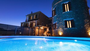 Una piscina con un edificio de piedra al fondo.