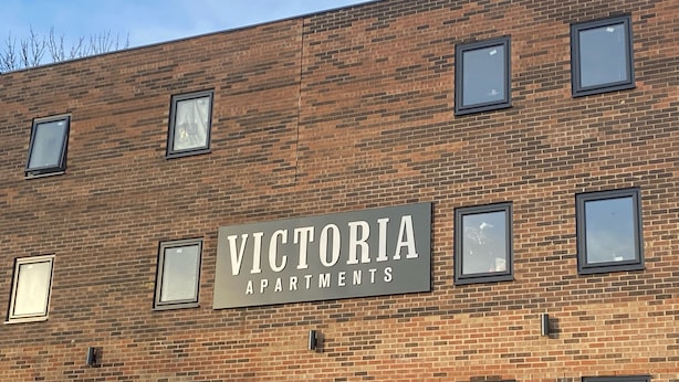 Ein Backsteinhaus mit einem Schild, auf dem „Victoria Apartments“ steht.