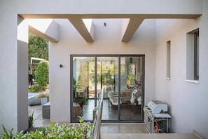 Un espacio exterior moderno con un ventanal de vidrio que da a un patio.