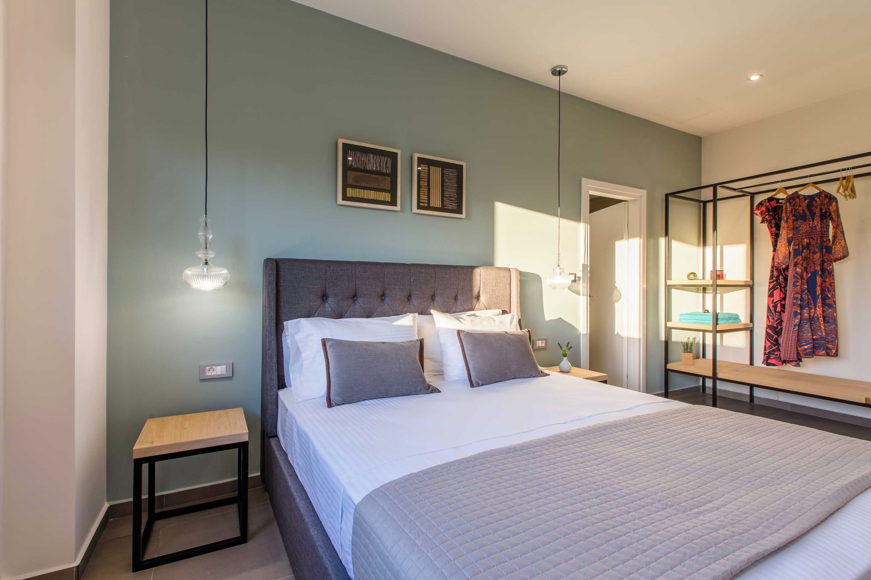 Een slaapkamer met een bed, nachtkastjes, een kledingkast en een spiegel.