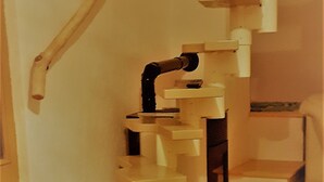 A wooden spiral staircase with a handrail and steps leading to a landing.
