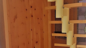 A room with a wooden floor, a wooden wall with a door, and a white staircase.