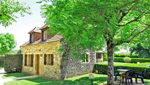 Un bâtiment en pierre avec un toit en pente et un petit porche.