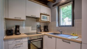 Une cuisine compacte équipée d’un four à micro-ondes, d’une cuisinière, d’un four et d’un évier.