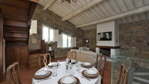 A dining area with a stone wall, wooden ceiling, and a fireplace. - Gittori, Gaiole in Chianti, Siena and Chianti (Gaiole in Chianti)