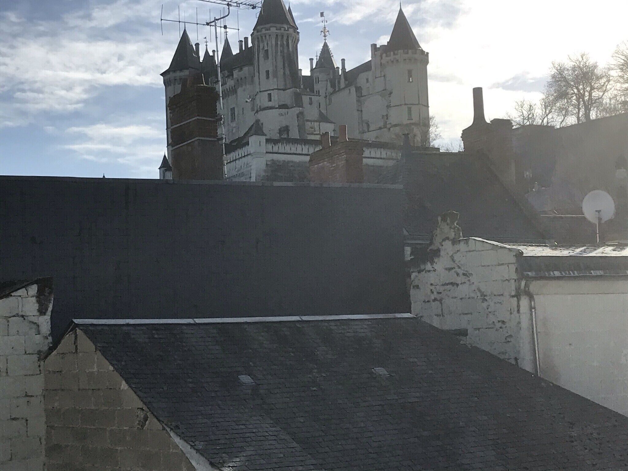 Un edificio que recuerda a un castillo, con varias torres y un techo empinado.