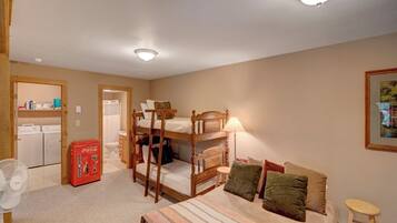 A room with bunk beds, a fan, a Coca-Cola vending machine, and a small stool.