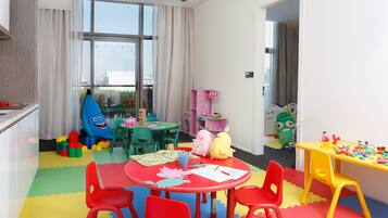 Una sala de juegos infantiles con mobiliario colorido, juguetes y material educativo.