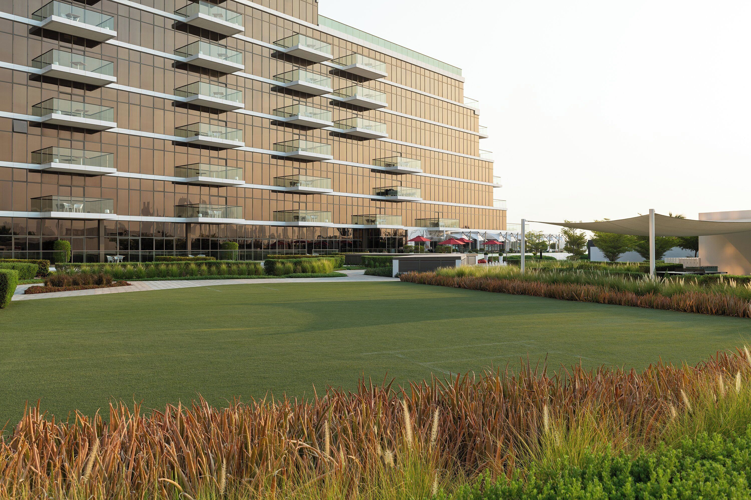 A modern building with multiple balconies and a well-maintained lawn area.
