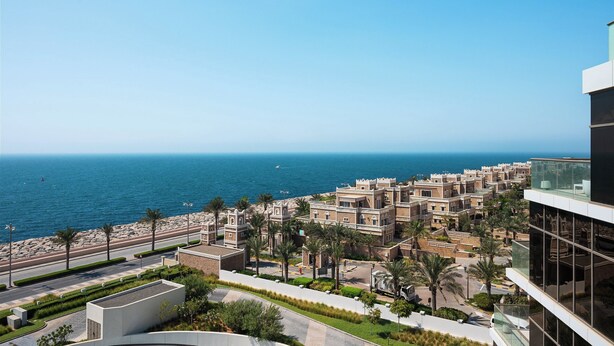 A coastal view with traditional architecture, a clear sky, and a calm sea. - Th8 Palm Dubai Beach Resort, Vignette Collection by IHG (Dubai)