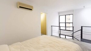 A bedroom with a bed, a window, a door, and a radiator. - Cool Duplex Studio Comfort & Great Location (São Paulo)