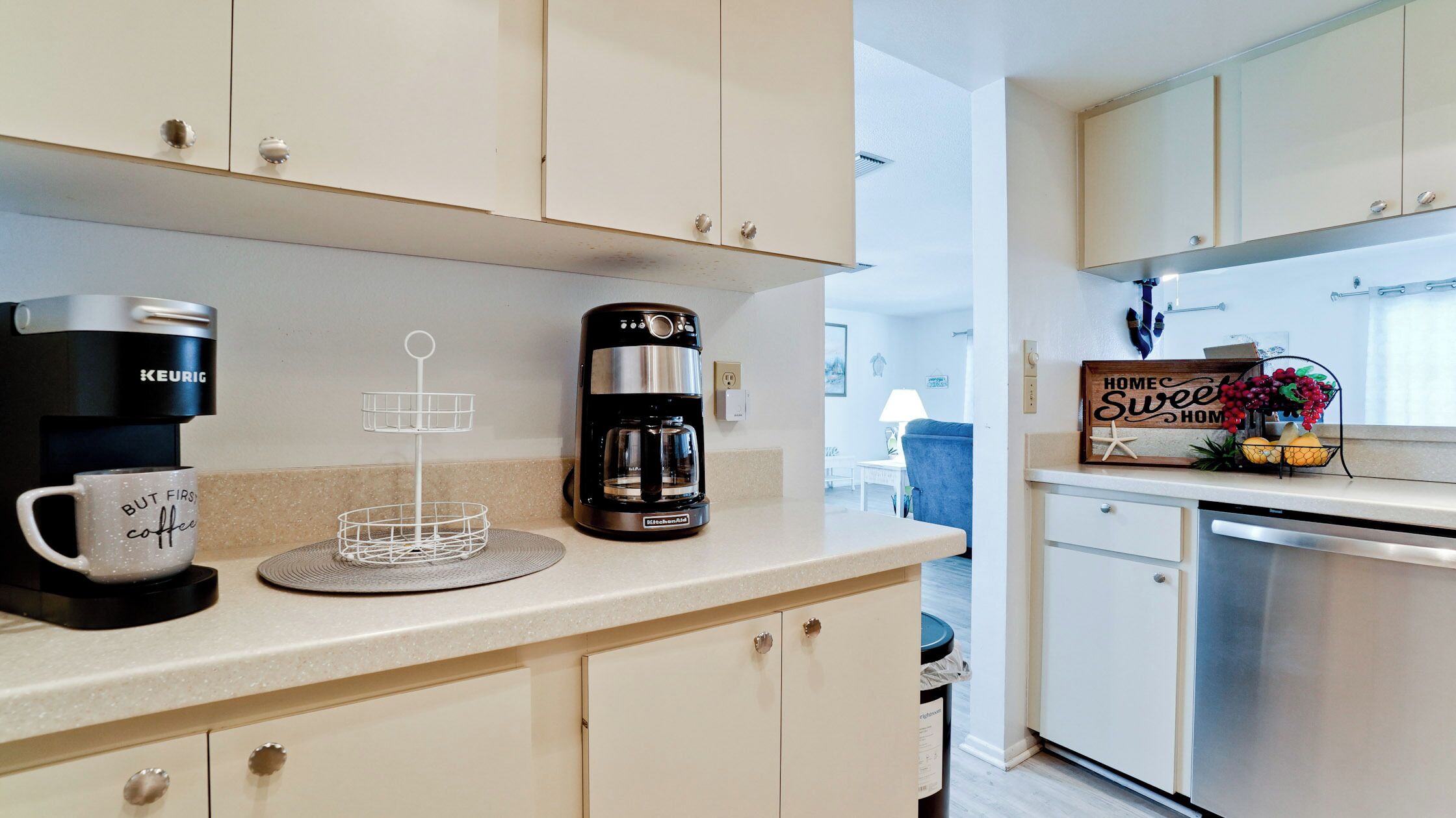 A kitchenette with a Keurig coffee maker, a coffee cup, and a KitchenAid coffee maker.