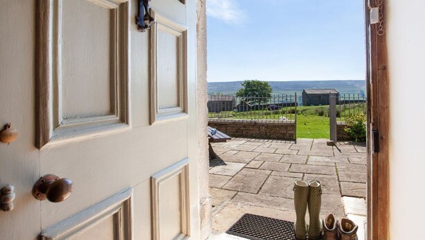A door leading to a patio with a view of a rural landscape. - HEATHERDENE - Cottage set in the midst of the Yorkshire Dales with amazing views (Richmond)