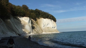 Ein felsiger Strand mit einer Klippe und dem Ozean.