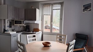 Una cucina funzionale con angolo ristoro, forno a microonde, macchina del caffè e finestra con tende.