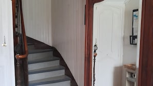 Una scala con ringhiera in legno e un grande specchio a parete.