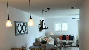 A modern kitchen with white cabinets and black handles, a dining area with a round table, and a living room with a sofa and a coffee table. - 💗☀️🌊Family Fun In The Sun🌊☀️💗 - 3 BR, 3.5 BA & Pet Friendly Townhouse (Little River)