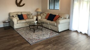 A living room with two sofas, a glass coffee table, a rug, a ceiling fan, a window with blinds, and a wall-mounted anchor decoration. - 💗☀️🌊Family Fun In The Sun🌊☀️💗 - 3 BR, 3.5 BA & Pet Friendly Townhouse (Little River)