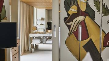 Ein modernes Interieur mit Küchenzeile, Esstisch und einem großen Kunstwerk an der Wand.
