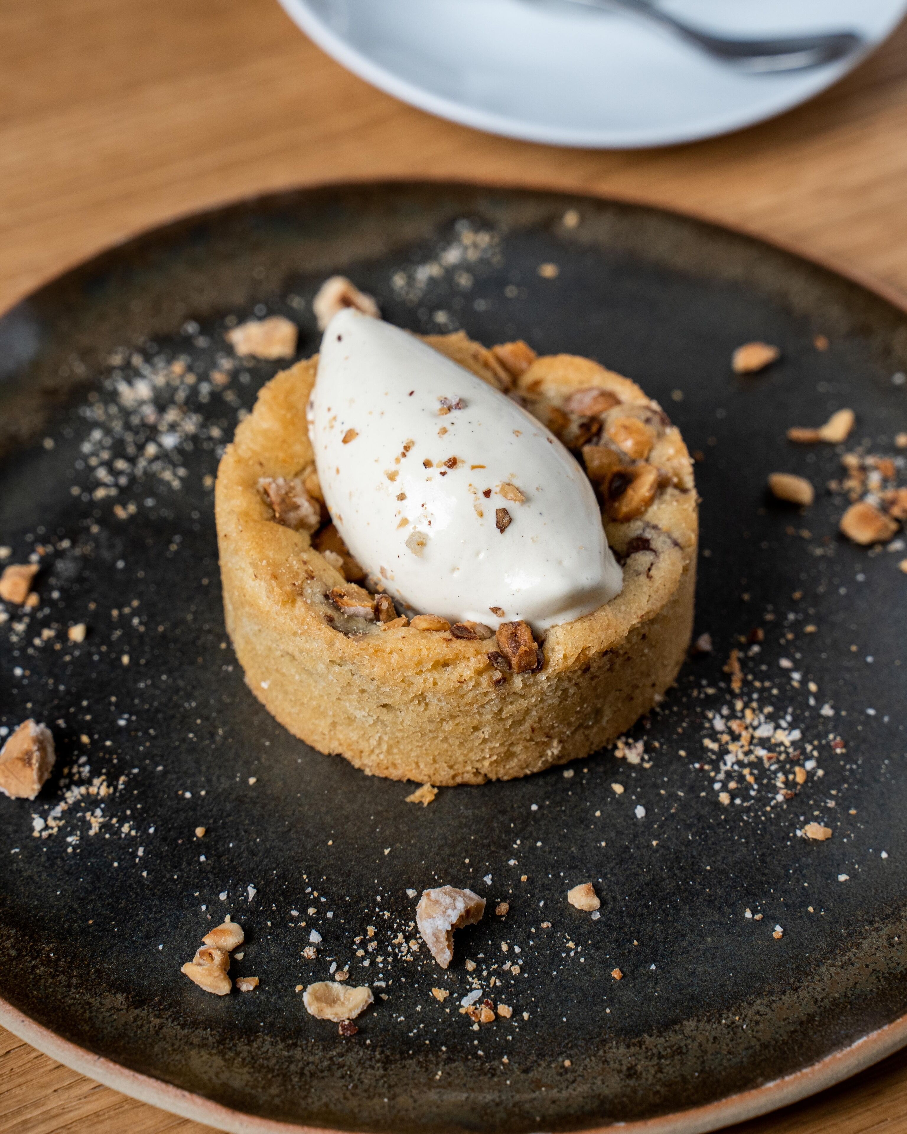 Un postre sobre un plato oscuro con una cuchara.