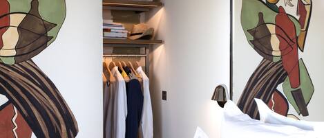 A hotel room with a bed, a wardrobe, and a mirror.