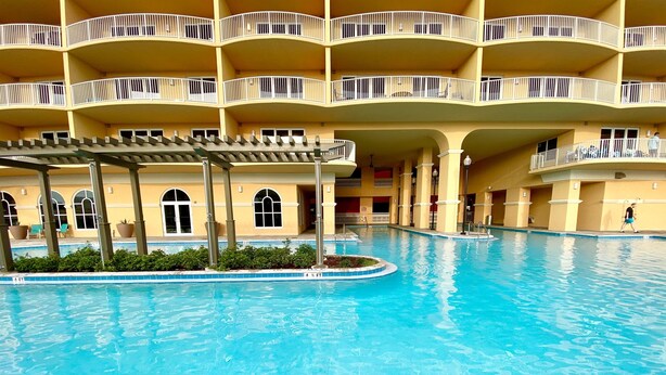 A large indoor swimming pool with a multi-level building in the background. - Flip Flop at Calypso III. Luxury, view, location and amenities. Sleeps 9 (Panama City Beach)