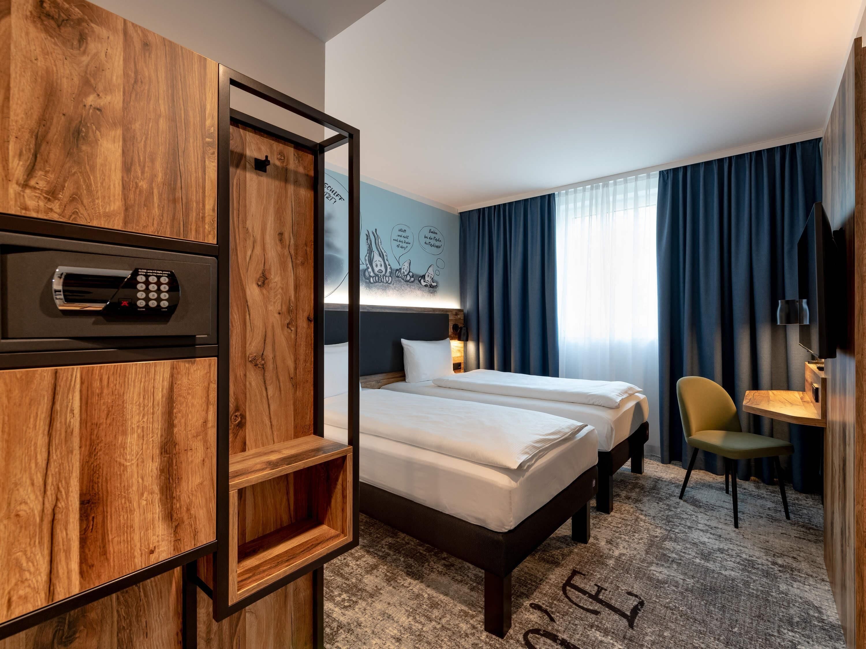 Une chambre d’hôtel avec un meuble en bois, un lit, une chaise, un bureau et un téléviseur.