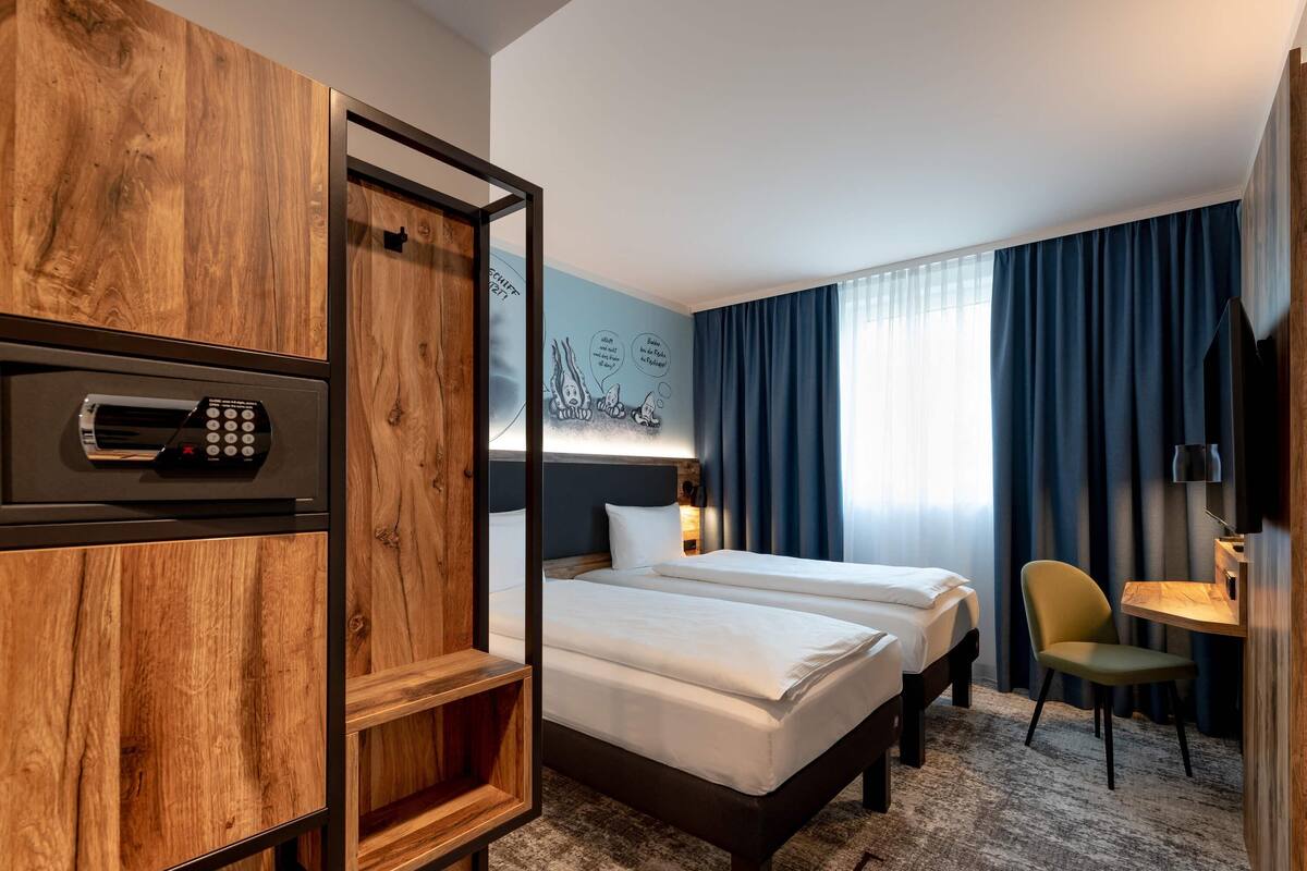 Une chambre d’hôtel avec un meuble en bois, un lit, une chaise, un bureau et un téléviseur.