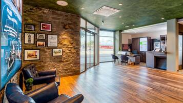A modern reception area with a stone wall, leather seating, a reception desk, and a view of the outside.