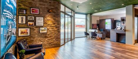 A modern reception area with a stone wall, leather seating, a reception desk, and a view of the outside.