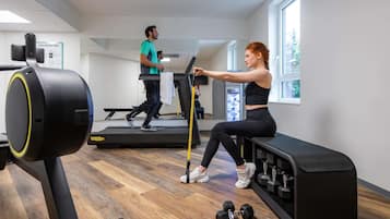 A gym with treadmills, a stationary bike, and dumbbells.