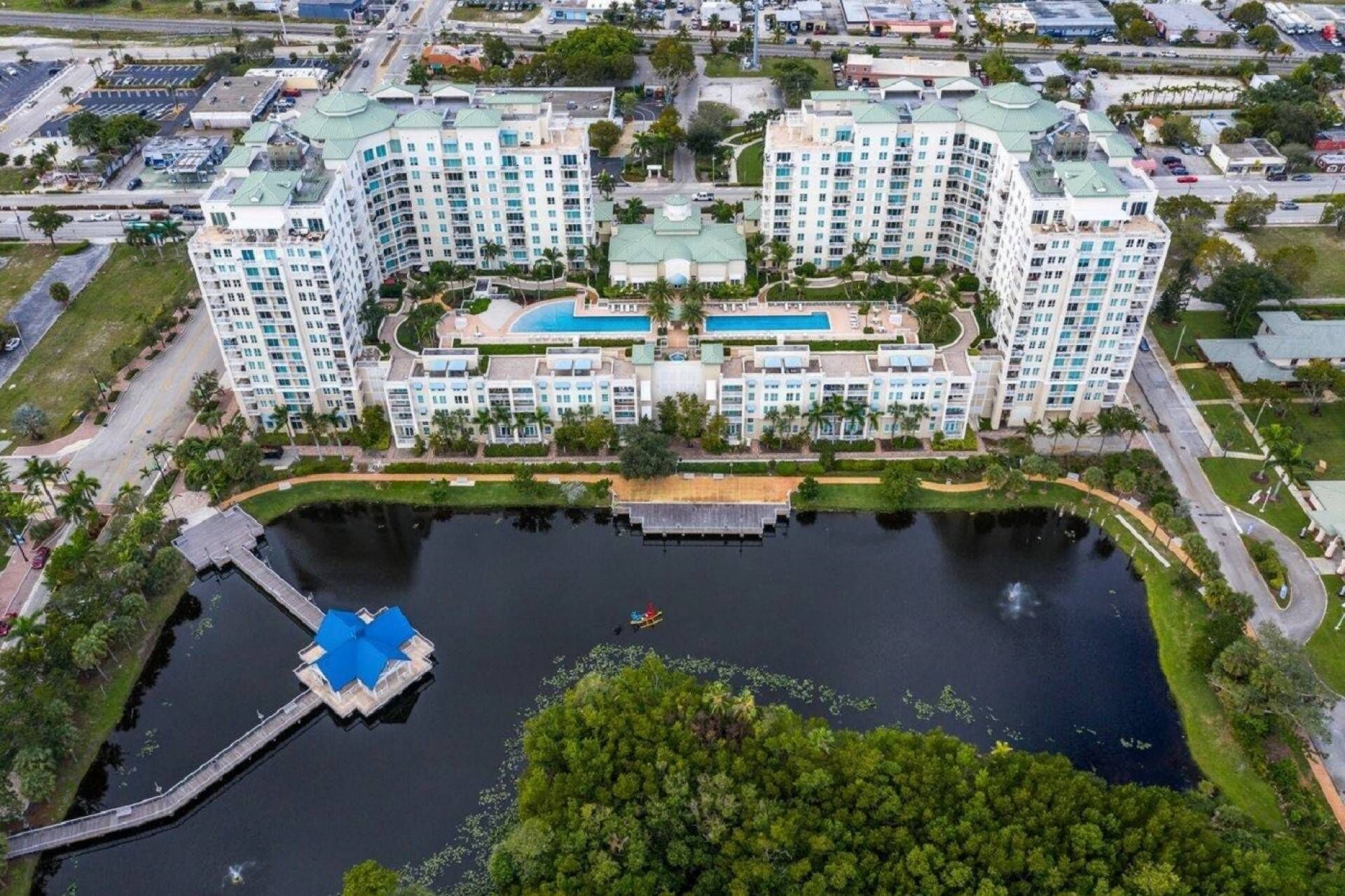 A large hotel with multiple high-rise buildings, a central pool, and a dock area.